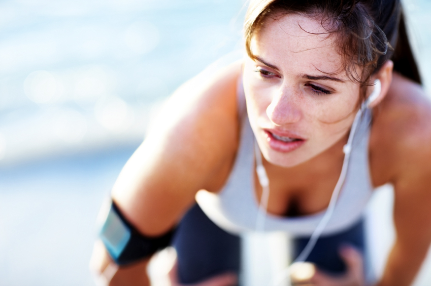 Portrait of a tired young female resting after jogging on bright background